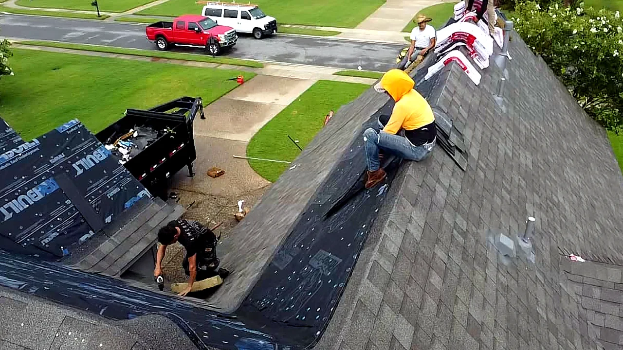 Crew tearing off and reshingling a roof beside the jobsite dumpster
